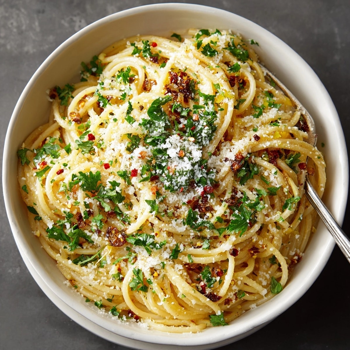 Fermented Garlic Pasta with Gut-Health Black Garlic twirled on a fork, glistening with savory sauce and fresh herbs.