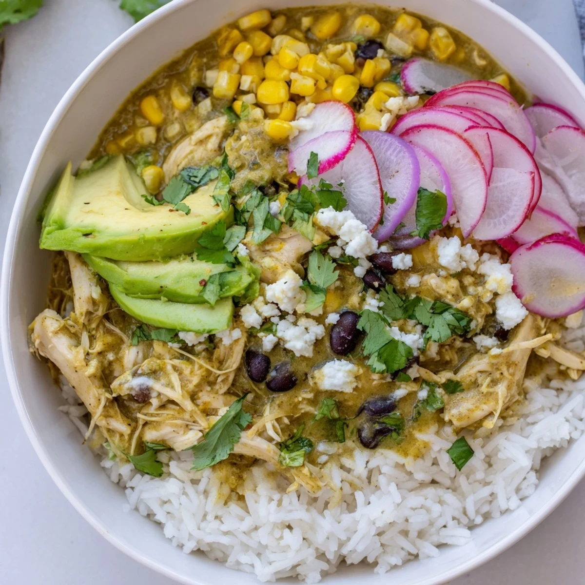 A close-up shot of a colorful Green Enchiladas Rice Bowl, showcasing fresh toppings piled high.