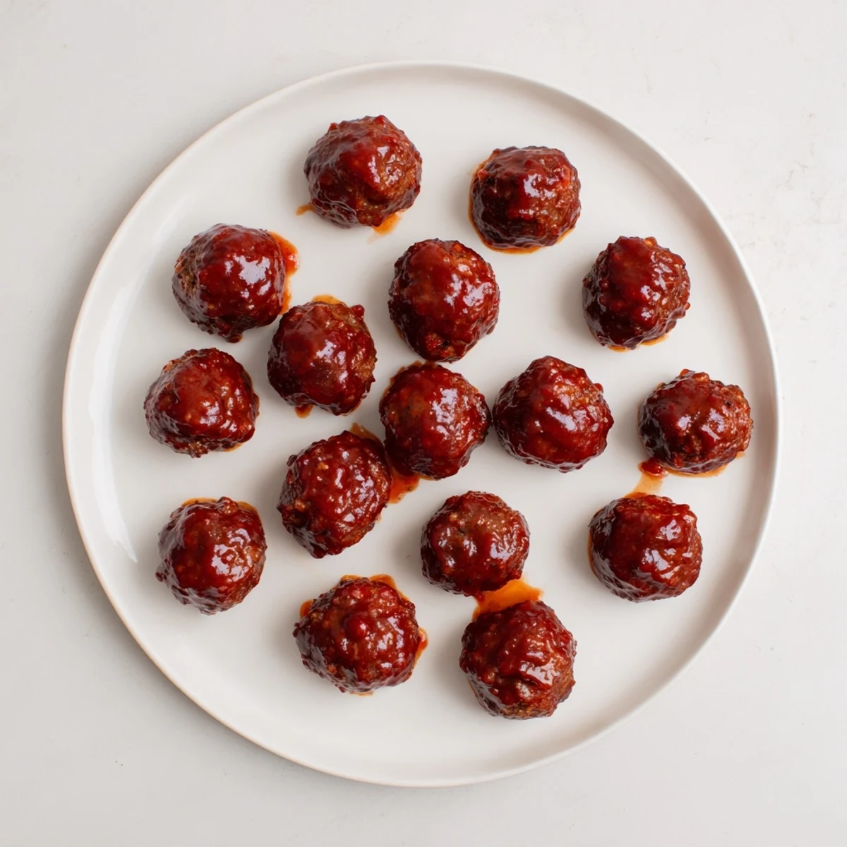 Baked cherry-glazed meatballs glistening with a sweet, tangy sauce, perfect for party appetizers.