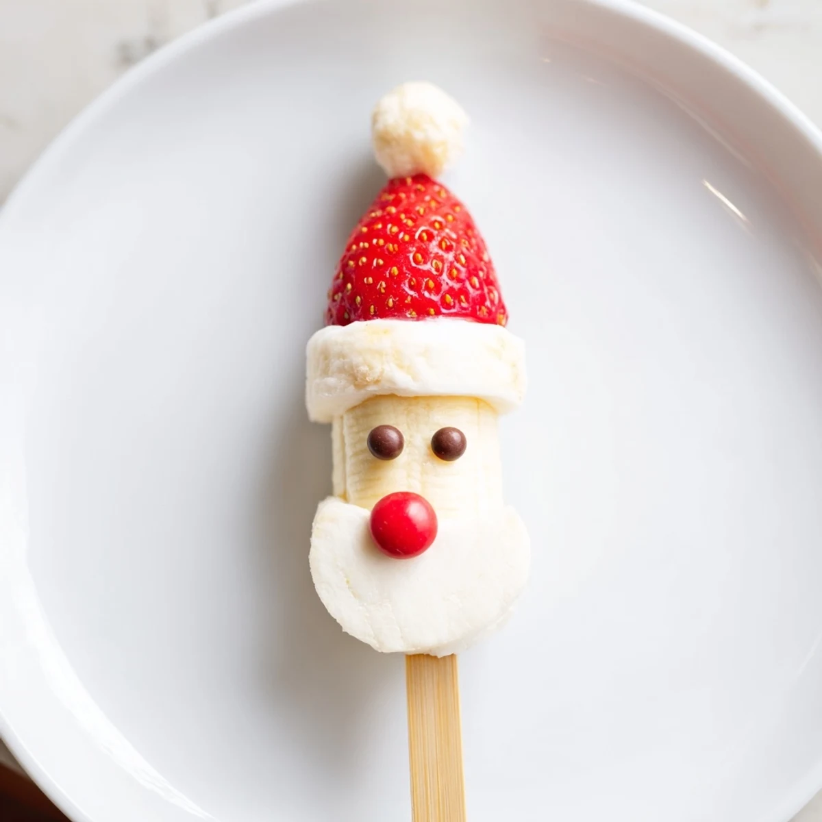 Banana Santa Snack Sticks on skewers with fresh strawberries and creamy marshmallows, a festive treat.