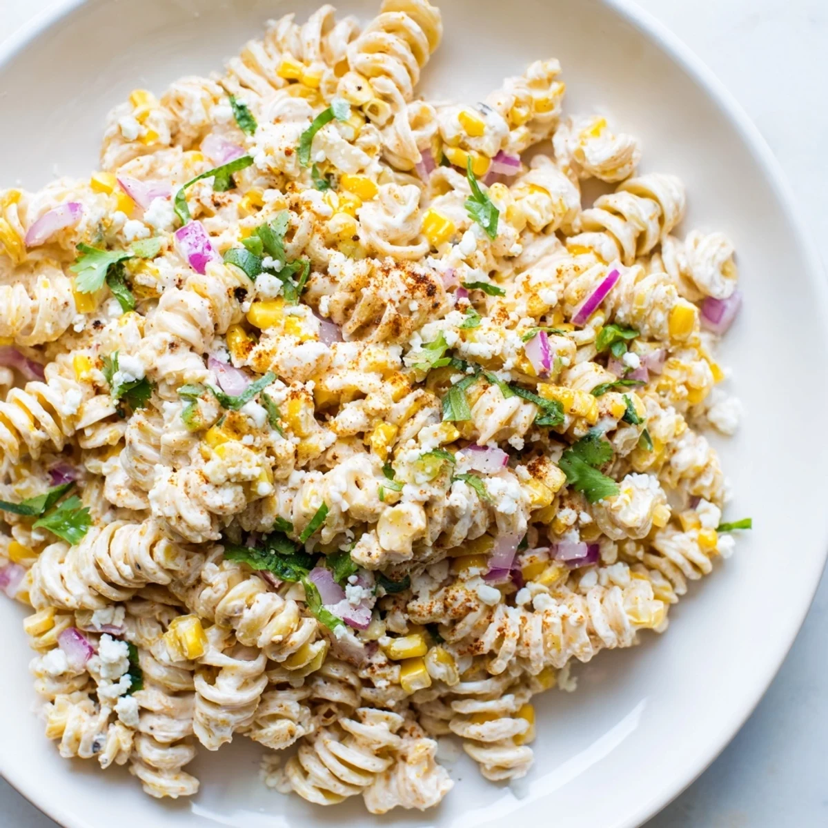 A close-up view of the Creamy Street Corn Pasta Salad, showcasing the fresh cilantro and cotija.