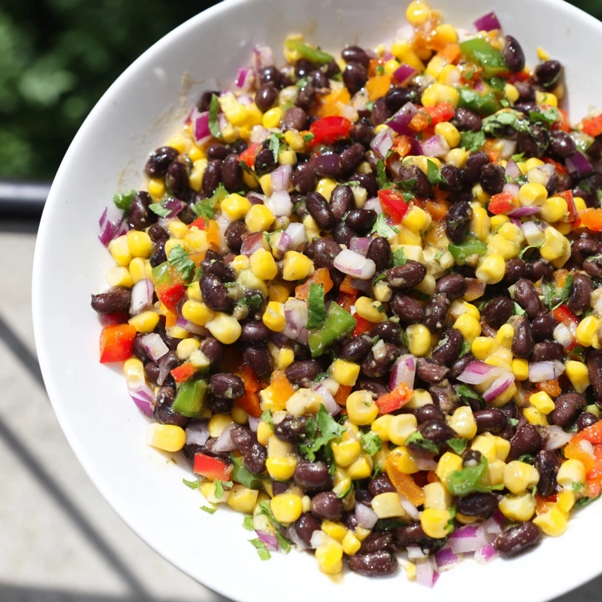 Close-up of freshly made Cowboy Caviar Salad, featuring a zesty lime dressing and bright veggies.