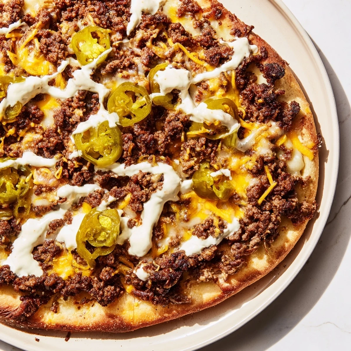Golden crust topped with seasoned ground beef and melted cheese in this Taco Pizza recipe.