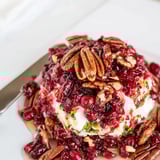 Vibrant cranberry jalapeño dip served with crackers, a sweet and spicy delight.