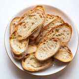 A warm, inviting image of a ring of baguette slices, perfect with a garlic-infused olive oil glaze.