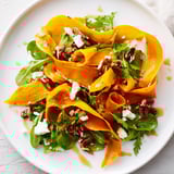 Tender roasted carrot ribbons artfully arranged on vibrant greens with crumbled feta and toasted pecans, drizzled with glossy honey–mustard dressing.
