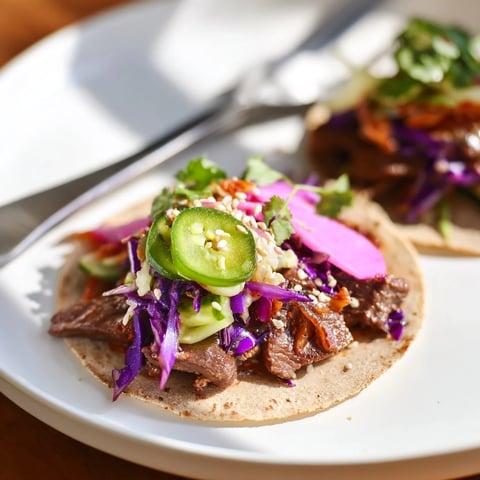 Delicious Global Street-Food Fusion Tacos topped with colorful veggies and zesty ube crema.  