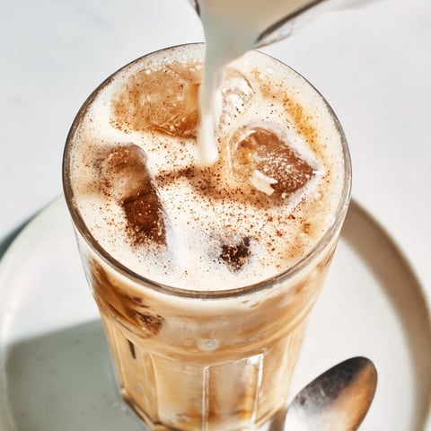 Creamy tahini iced coffee with ice cubes, drizzled for delicious summer refreshment.  