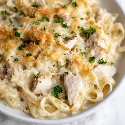 Golden-brown Chicken Fettuccine Alfredo Bake bubbling in a dish with a cheesy, irresistible topping.