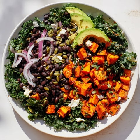 Close-up of a delicious Massaged Kale Salad with vibrant sweet potato and avocado slices.