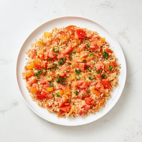 Steaming Tomato-Rice Skillet Dinner features fluffy rice, juicy tomatoes, and fresh parsley garnish, ready to serve.