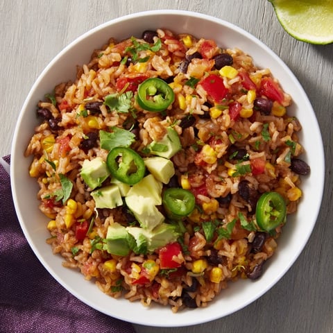 Steaming bowl of One-Pot Mexican Rice & Beans, with fresh cilantro and a squeeze of lime.