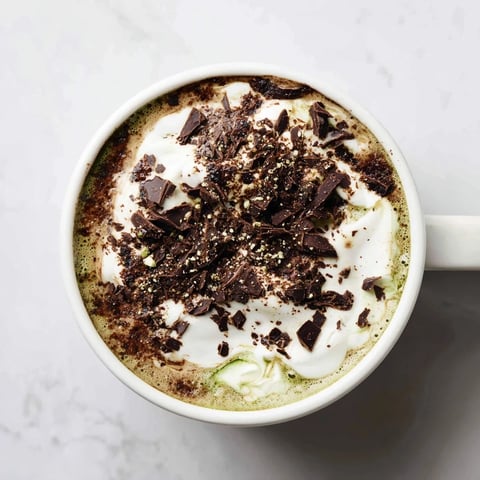 A creamy, cool Collagen Peppermint Mocha Matcha Latte swirled with frothy, rich cocoa and matcha flavors.