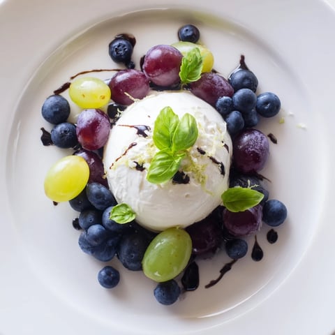 The Moonlit Lagoon salad with creamy burrata, juicy grapes, and blueberries, drizzled with balsamic.