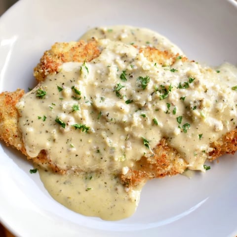 Golden, crispy chicken with garlic cream sauce, perfectly plated, ready for a delicious dinner.