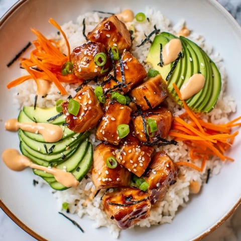 Vibrant teriyaki salmon rice bowl, featuring moist, glazed salmon atop fluffy rice with fresh veggies.