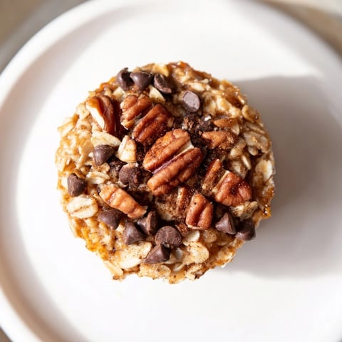 Golden-brown Baked Oatmeal Cups, each studded with berries, offer a warm, comforting breakfast.