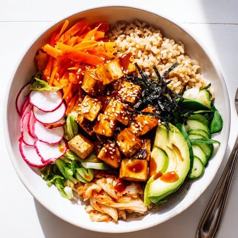 Hearty grains topped with tangy kimchi, fresh vegetables, and rich sesame dressing.  