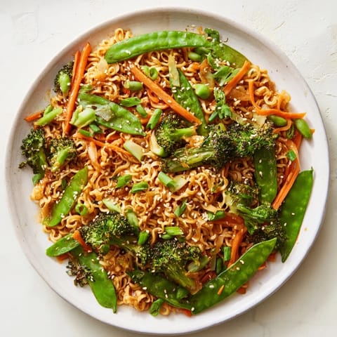 Vibrant photo of a plate of delicious Ramen Noodle Stir-Fry Remix, ready to eat with sesame seeds.
