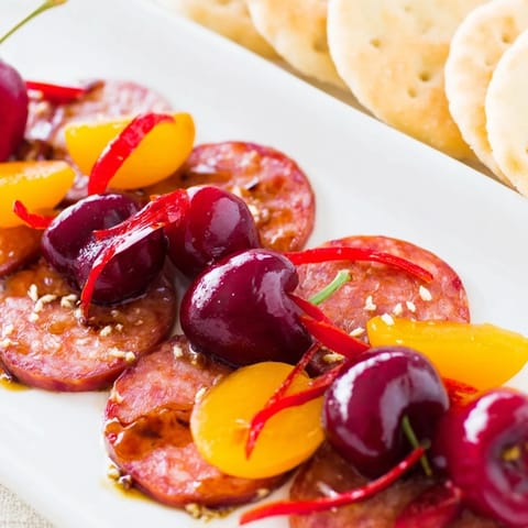 The eye-catching Crimson Tide appetizer, featuring vibrant red ingredients perfectly complements white crackers.