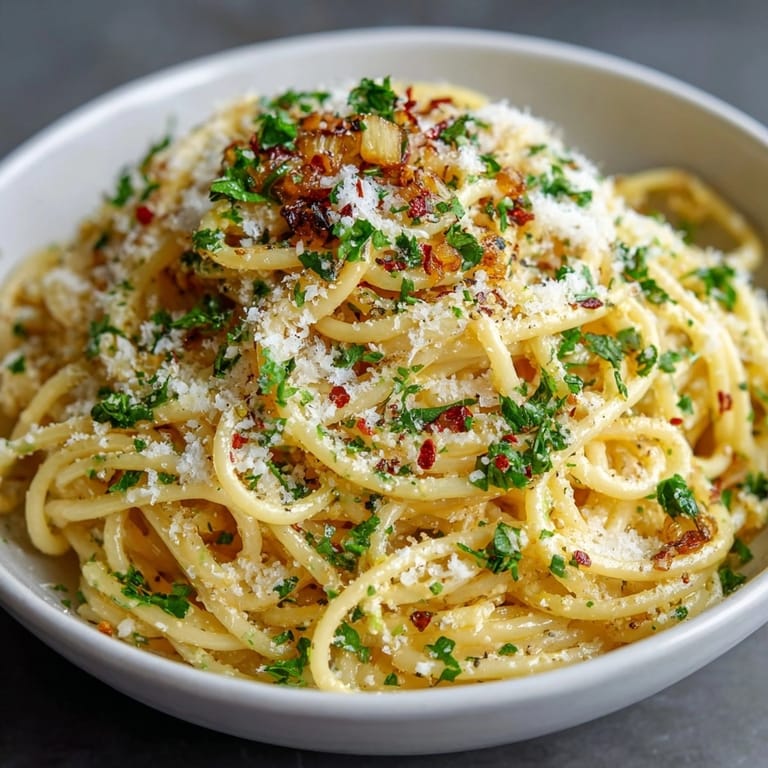 Bowl of Fermented Garlic Pasta with Gut-Health Black Garlic, topped with grated cheese and parsley for a vibrant finish.