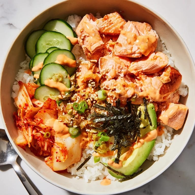 Savor a colorful Crispy Salmon Rice Bowl with fluffy rice and fresh cucumber.