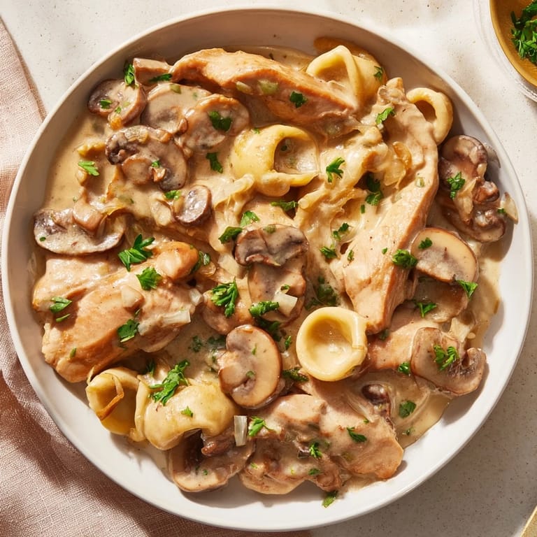 A steaming bowl of Creamy Chicken Stroganoff, garnished with parsley and perfect for a warm dinner.