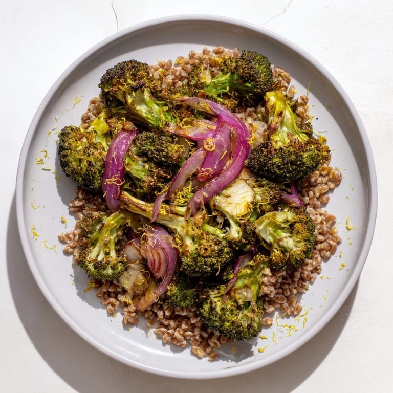 Warm roasted broccoli with tender farro, drizzled with bright lemon dressing, perfect as a vegetarian meal.