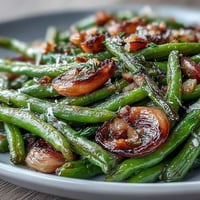 Roasted garlic green beans with caramelized garlic and lemon zest for a savory side dish.  