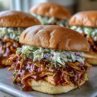 Pulled BBQ Chicken Sandwiches with juicy, smoky chicken and tangy sauce on soft brioche buns.